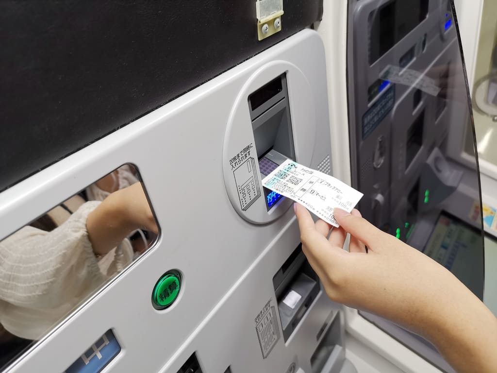 將中獎的馬券放入售票機兌獎 將中獎的馬券放入售票機兌獎